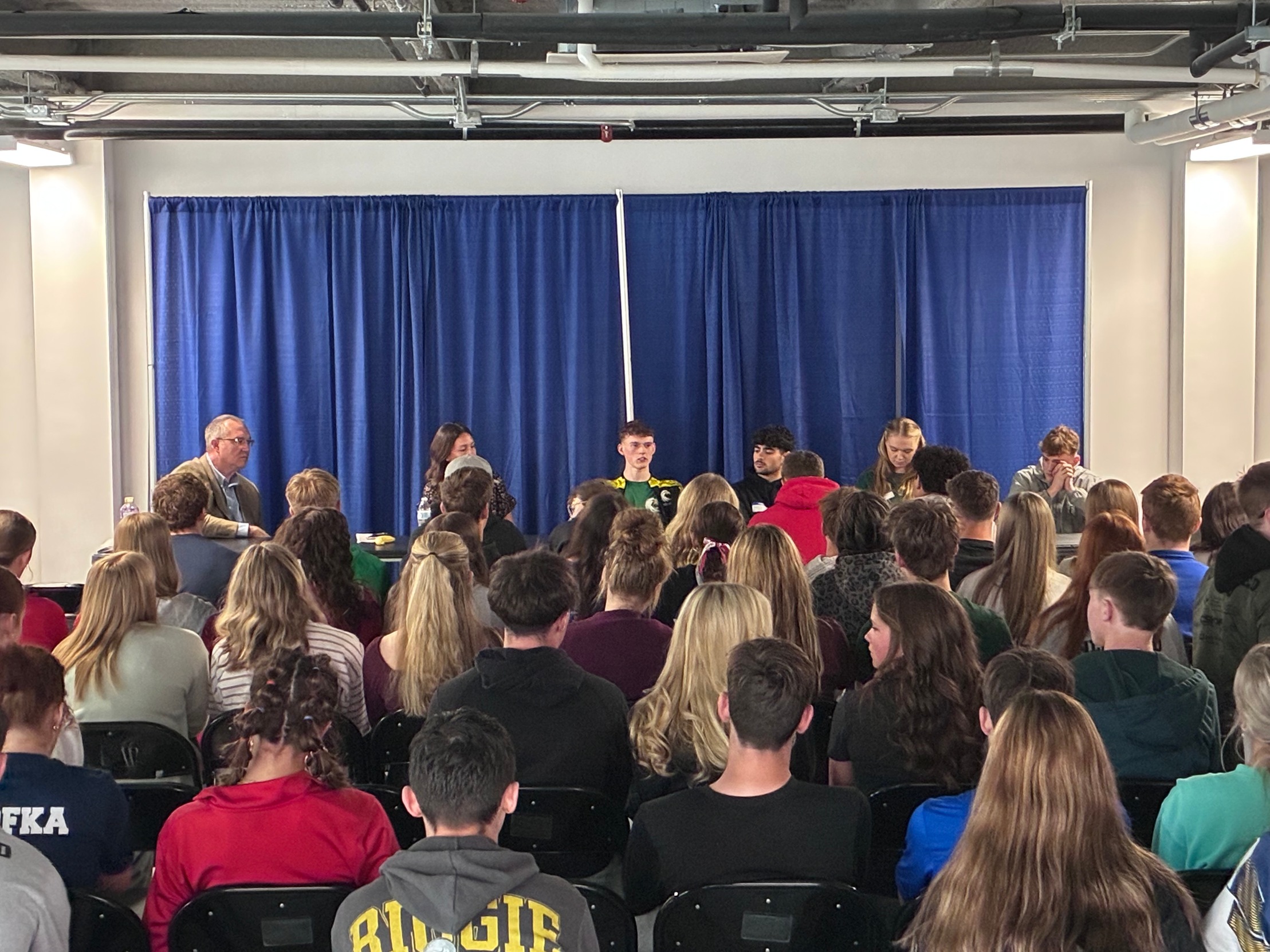 Four JCC student-athletes speaking in front of a crowd at Northwest Arena
